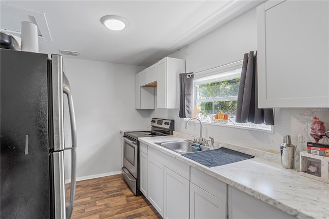 kitchen featuring baseboards, dark wood-style floors, appliances with stainless steel finishes, white cabinetry, and a sink