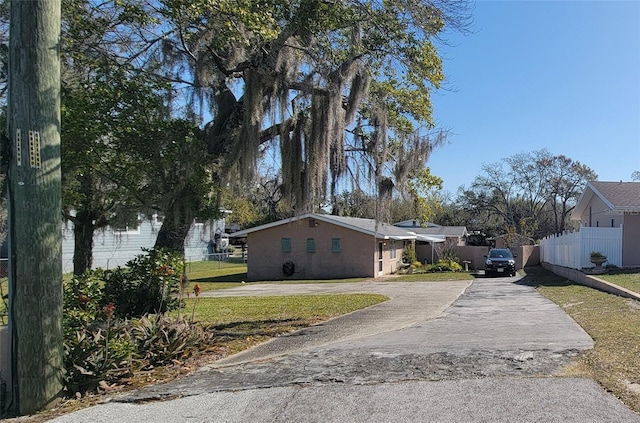 view of front of house with a residential view, concrete driveway, and fence