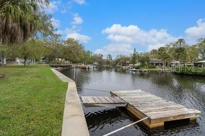 dock area featuring a water view and a yard