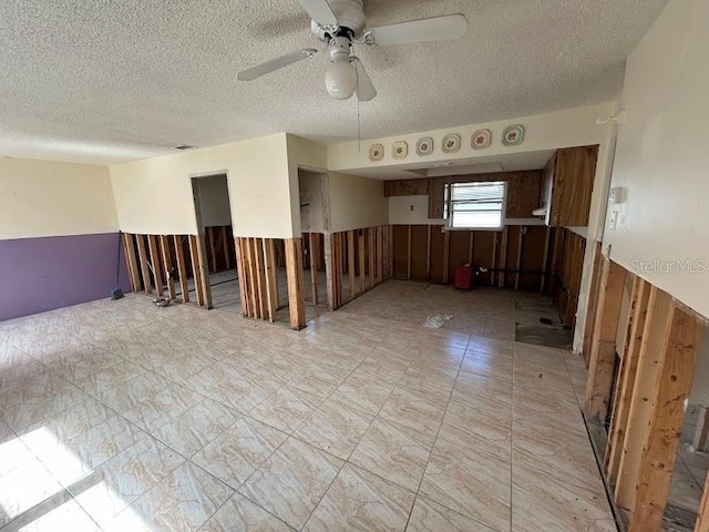 spare room featuring a ceiling fan and a textured ceiling