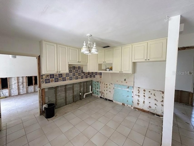 kitchen with a notable chandelier, open shelves, visible vents, hanging light fixtures, and cream cabinets