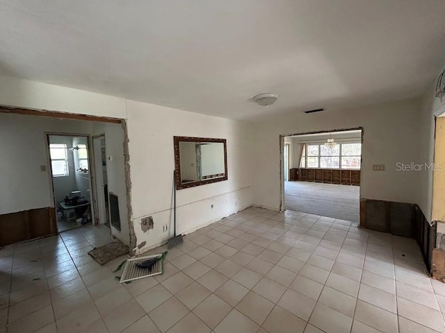 empty room with light tile patterned flooring, visible vents, and a healthy amount of sunlight