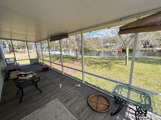 unfurnished sunroom featuring a water view