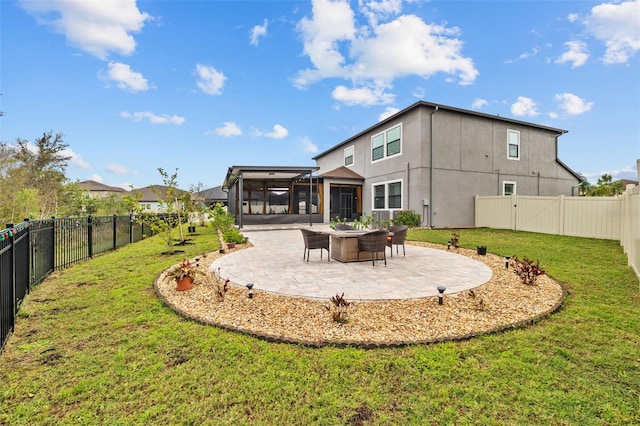 back of house with a lawn, an outdoor fire pit, a sunroom, a patio area, and a fenced backyard