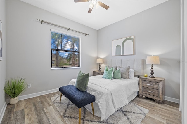 bedroom featuring a ceiling fan, baseboards, and light wood finished floors