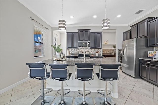 kitchen featuring stainless steel appliances, visible vents, an island with sink, and light tile patterned flooring