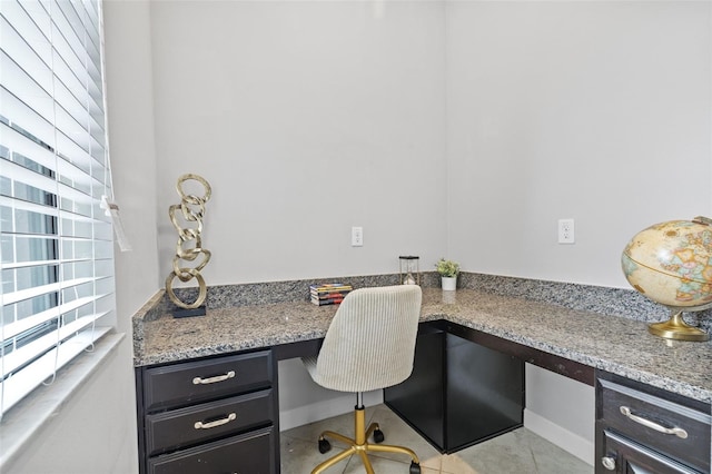 home office featuring built in study area and light tile patterned floors