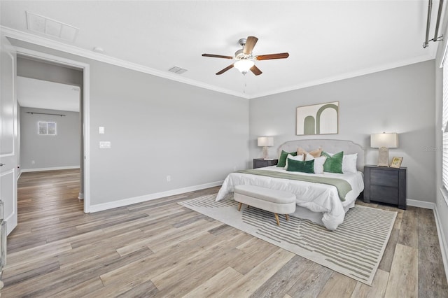 bedroom featuring light wood-style floors, ornamental molding, and baseboards