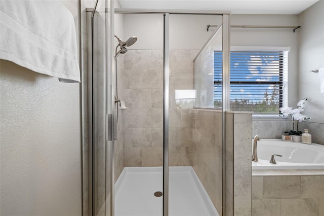 full bathroom with a shower stall and a bath