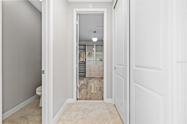 hall with light tile patterned flooring and baseboards