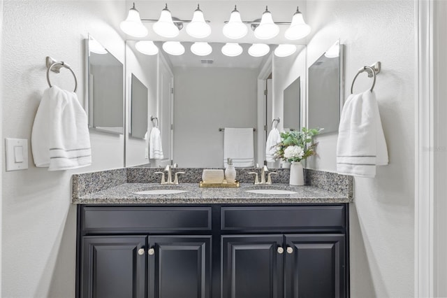 full bath featuring visible vents, a sink, and double vanity