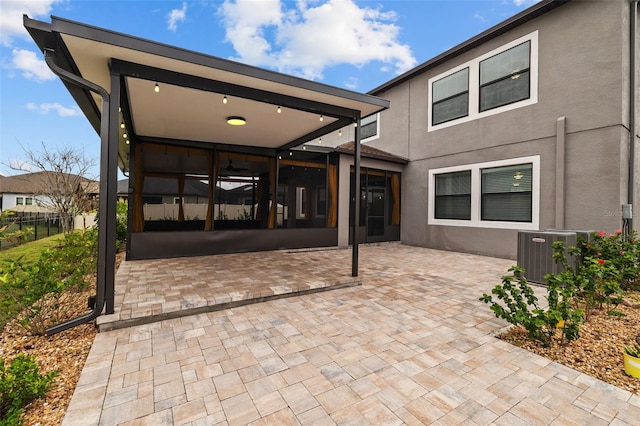 back of house featuring a patio, fence, central AC, and stucco siding