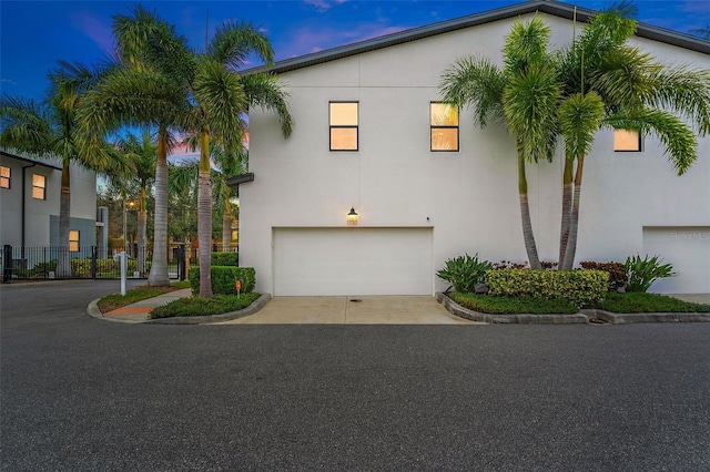 view of front facade featuring driveway, an attached garage, and stucco siding