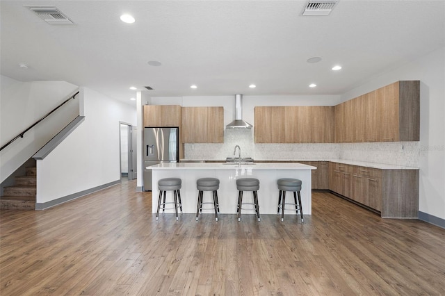 1110 25th St N, Saint Petersburg, FL 33713 - kitchen with a center island with sink, visible vents, modern cabinets, light countertops, and wall chimney range hood