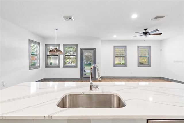 1110 25th St N, Saint Petersburg, FL 33713 - kitchen featuring visible vents, decorative light fixtures, a sink, light stone countertops, and a wealth of natural light