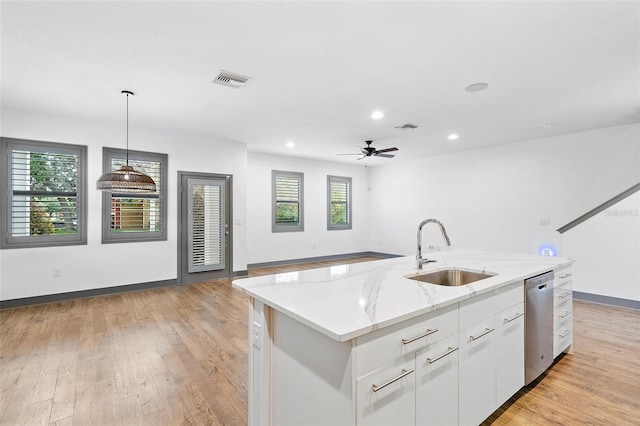 1110 25th St N, Saint Petersburg, FL 33713 - kitchen featuring a sink, white cabinets, open floor plan, a center island with sink, and decorative light fixtures