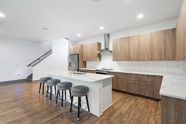 1110 25th St N, Saint Petersburg, FL 33713 - kitchen featuring stainless steel appliances, a breakfast bar, wall chimney exhaust hood, modern cabinets, and a center island with sink