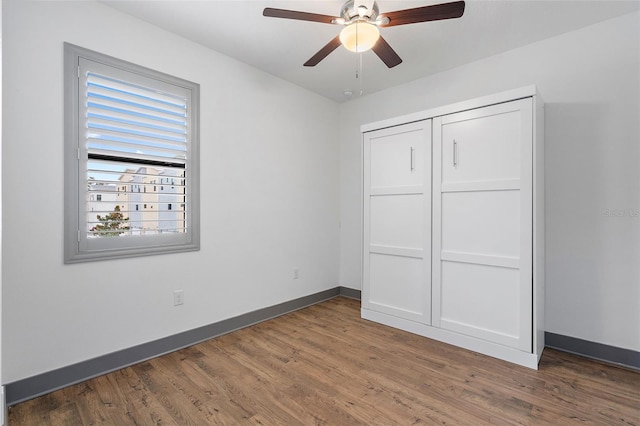1110 25th St N, Saint Petersburg, FL 33713 - unfurnished bedroom featuring a ceiling fan, a closet, baseboards, and dark wood-type flooring