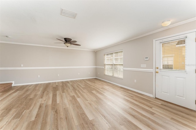 empty room with light wood-type flooring, visible vents, and crown molding