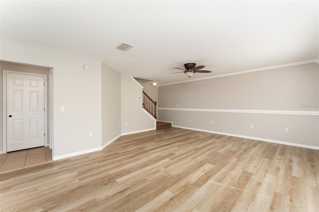 spare room with a ceiling fan, visible vents, stairs, baseboards, and light wood finished floors