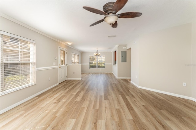 unfurnished living room with ceiling fan with notable chandelier, light wood finished floors, crown molding, and baseboards