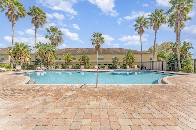 community pool featuring a patio and fence