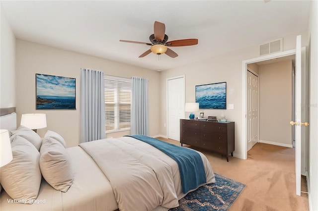 bedroom featuring baseboards, a ceiling fan, visible vents, and light colored carpet