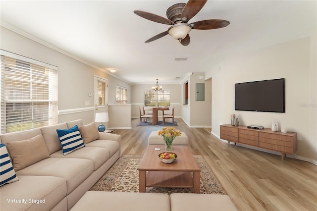 living room with light wood-style flooring, ornamental molding, baseboards, and ceiling fan with notable chandelier