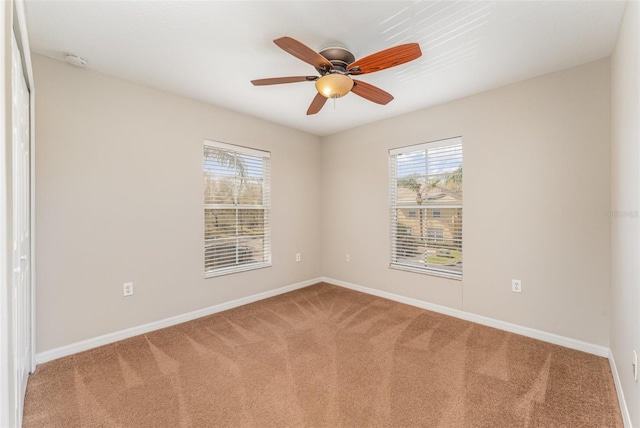 empty room featuring ceiling fan, carpet flooring, and baseboards