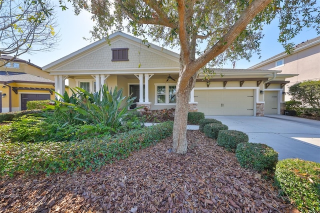 view of front facade featuring an attached garage, stone siding, concrete driveway, and stucco siding