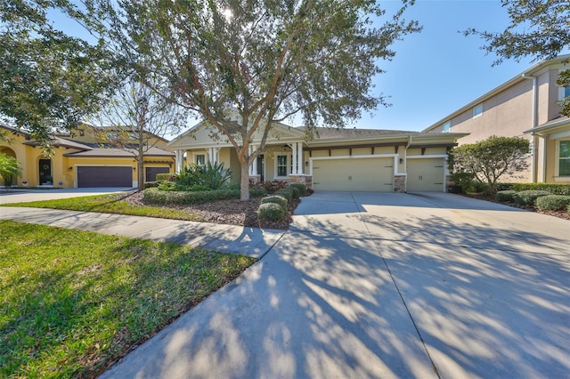 view of front of property with a garage, driveway, stone siding, and stucco siding