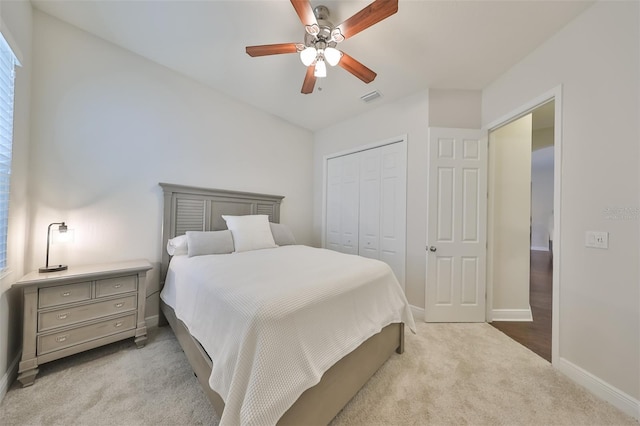 bedroom with light carpet, a closet, visible vents, and baseboards