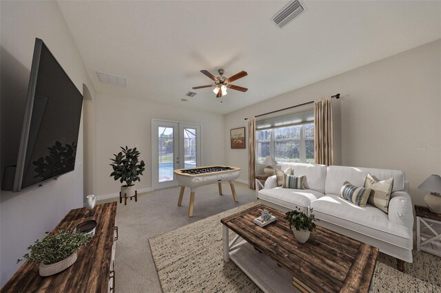 carpeted living room featuring baseboards, visible vents, a ceiling fan, and french doors