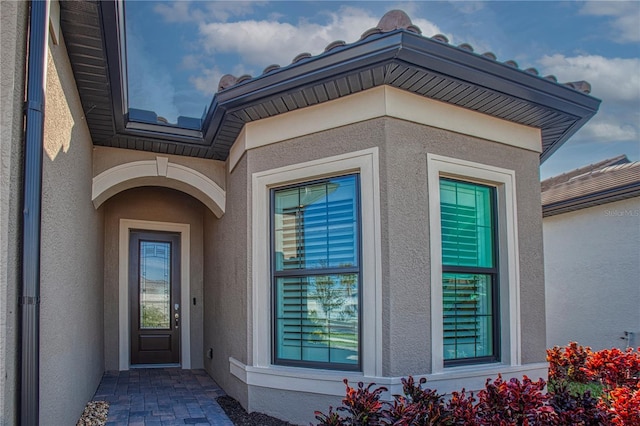 entrance to property featuring stucco siding