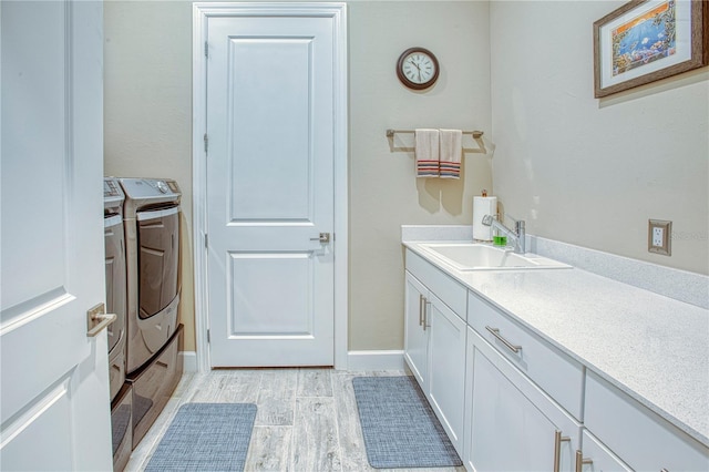 bathroom with wood finished floors, washing machine and clothes dryer, vanity, and baseboards