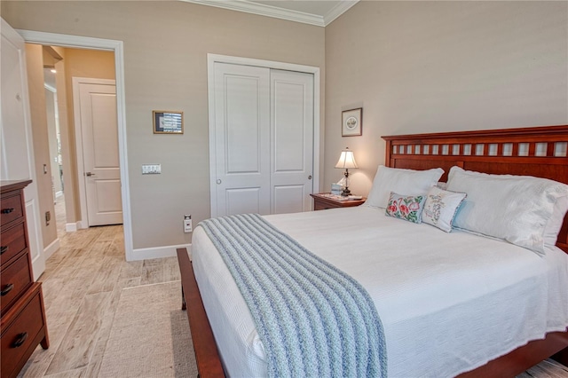 bedroom with ornamental molding, a closet, baseboards, and light wood finished floors