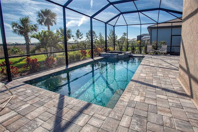 view of swimming pool with glass enclosure, a pool with connected hot tub, and a patio