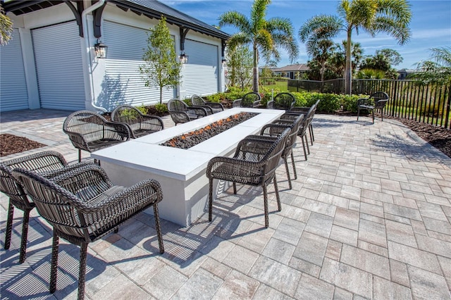 view of patio featuring an outdoor fire pit and fence