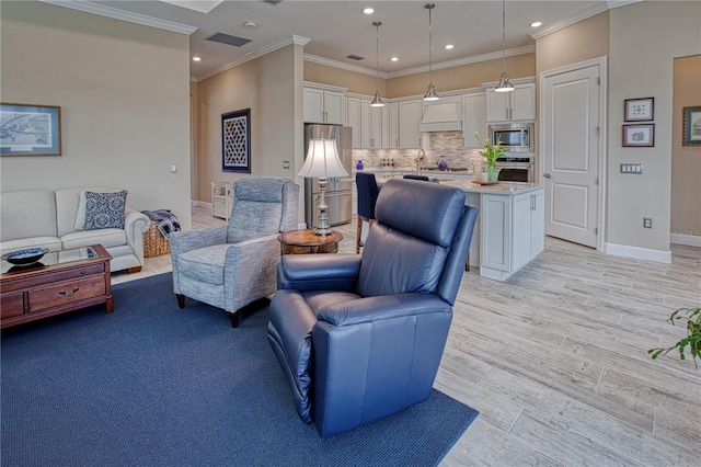 living room featuring recessed lighting, visible vents, baseboards, light wood-type flooring, and crown molding