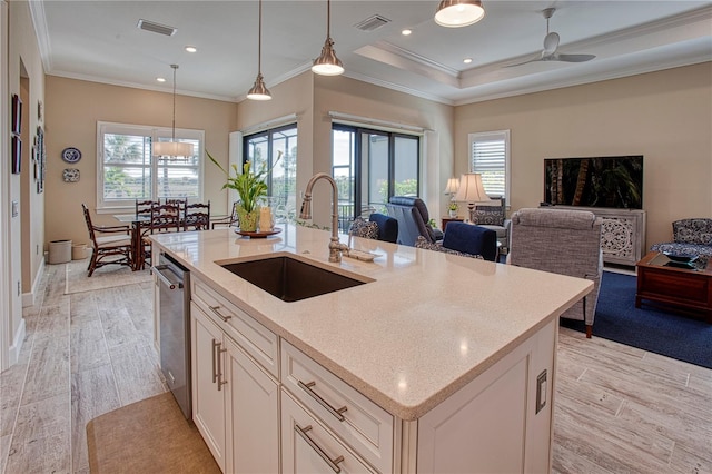 kitchen with open floor plan, light stone countertops, a kitchen island with sink, pendant lighting, and a sink