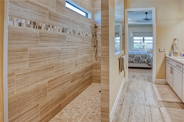 ensuite bathroom featuring ensuite bathroom, vanity, wood finished floors, baseboards, and walk in shower