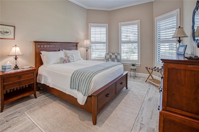 bedroom with baseboards, ornamental molding, and light wood-style floors