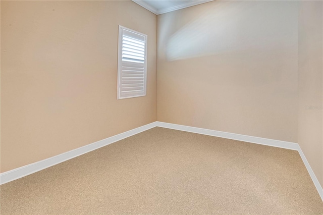 unfurnished room with ornamental molding, carpet flooring, and baseboards