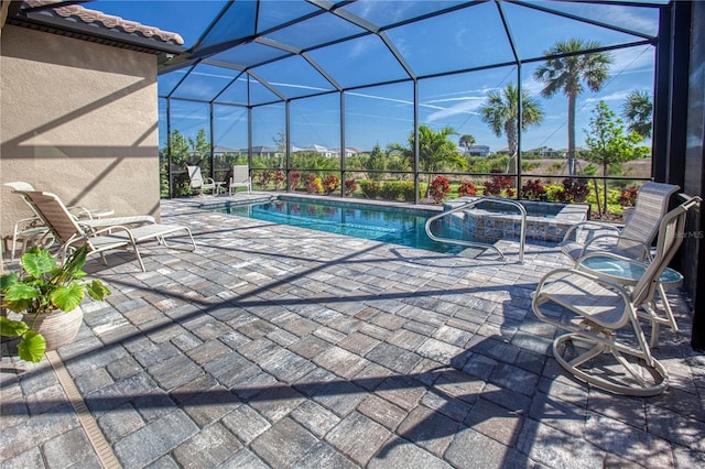 pool featuring an in ground hot tub, a patio, and glass enclosure