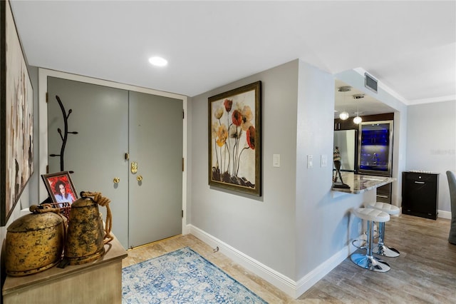 entryway featuring baseboards, visible vents, and light wood finished floors