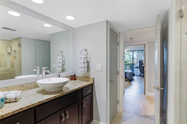 bathroom with visible vents, connected bathroom, vanity, a shower stall, and baseboards