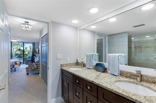 ensuite bathroom with a stall shower, visible vents, a sink, and double vanity