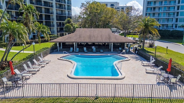 community pool with a patio area and fence