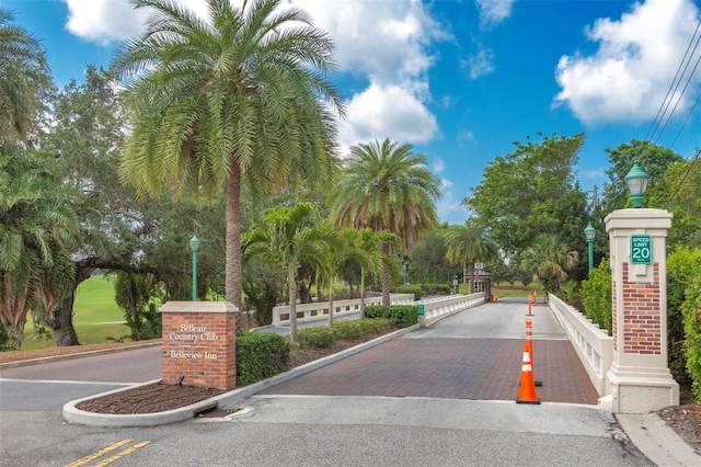 view of street featuring curbs, a gated entry, and street lights