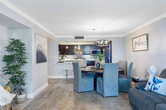 dining area with baseboards, visible vents, wood finished floors, crown molding, and a chandelier